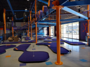 An AGS MiniLinks Course with purple turf and orange obstacles at the Altitude Trampoline Park in Round Rock, TX