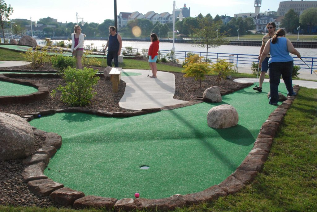 People enjoying outdoor miniature golf course hole at harbor pointe mini golf course in Sheboygan, WI