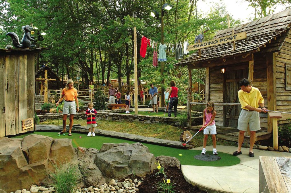 Family playing outdoor mini golf on Davey Crockett course in Tennessee