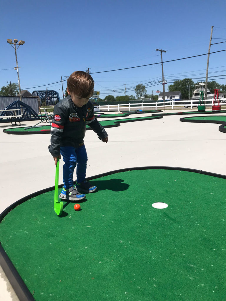 Child prepares to putt on the 18-hole Anywhere Links, Jr.® mini golf course at Romp’s Putter Port.