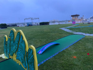 Portable mini golf putting green with obstacles including a thin, long bridge placed on top of the green at the American Express Event hosted for platinum card holders.