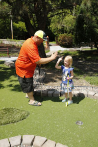 A father and daughter high-five in celebration on the newly renovated Modular Advantage® Mini Golf course installed by Adventure Golf & Sports in Richfield.