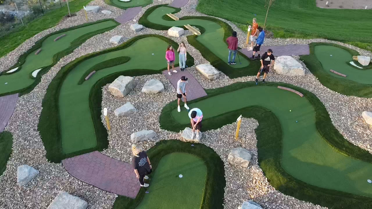 A few individuals putting on the Modular Advantage® mini golf course installed by AGS in Maryland Heights at Ryze Adventure Park.