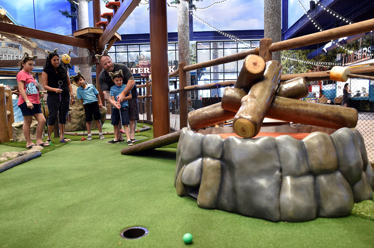 Dad helping son putt up ramp on Great Wolf Lodge Course