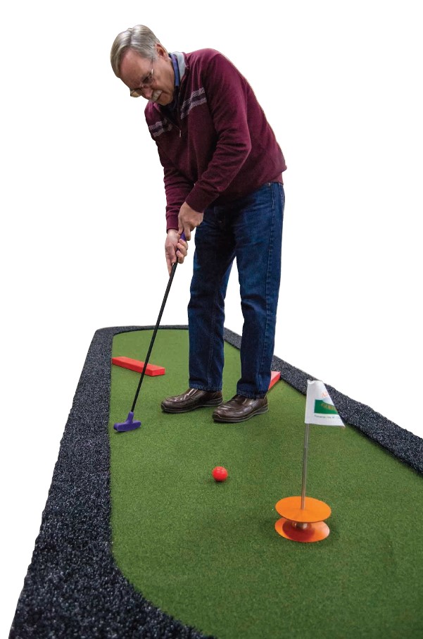 Player putting toward “Carpet Cup” that can capture golf ball on AGS RollOut™ Mini Golf hole.