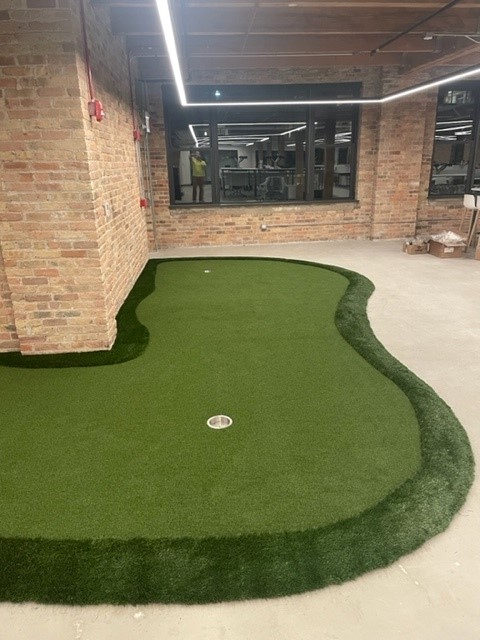A look down one side of a corner wall at the Urban Innovations Office shows 2 of 3 AGS custom modular putting green holes
