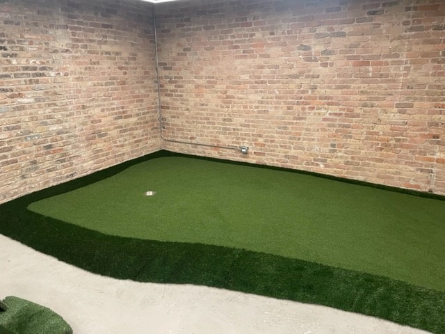 Looking down on an AGS custom modular putting green at the Urban Innovations Office in a Chicago building.