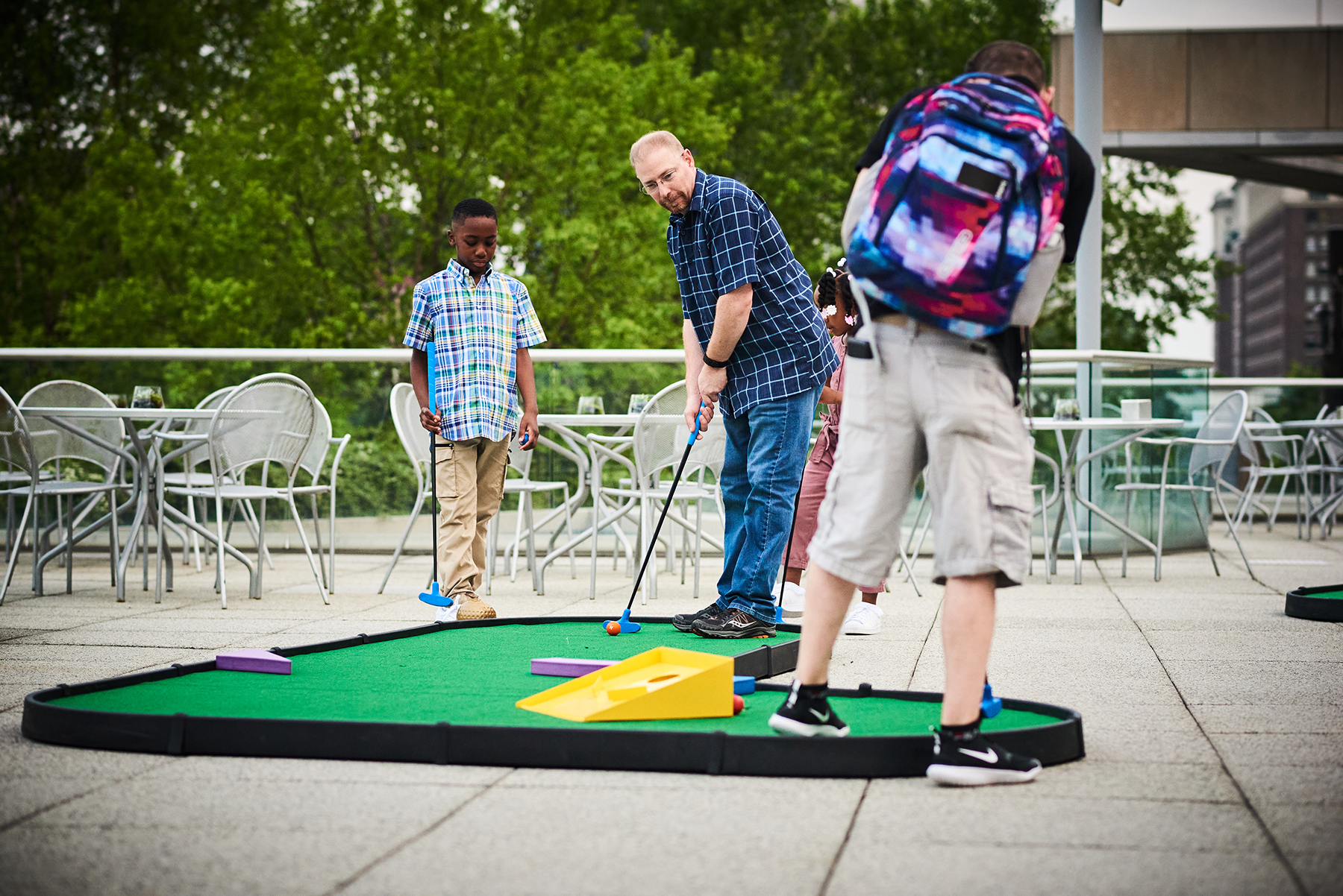 Players putting around the obstacles on an AGS MiniLinks™ Jr. golf hole at a GWU event in Philadelphia, PA
