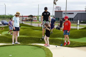 Family playing on AGS Bunkers & Bumps style mini golf course at FEC in Avondale, LA