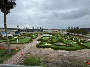 Mini golf holes being constructed with faux sand traps and undulations near the NOLA Motorsports park