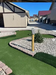 Hole 14 at Alpen Point features rough turf and a faux sand trap before reaching the hole cup