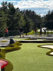Rough turf separates mini golf holes and serves as obstacles on the greens of this AGS-designed course