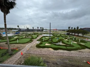 Mini golf holes being constructed with faux sand traps and undulations near the NOLA Motorsports park