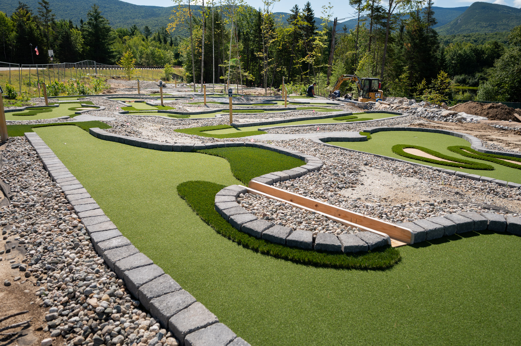 Varying turf, faux sand traps, and wood bridges adorn the AGS eco-friendly mini golf holes at the resort